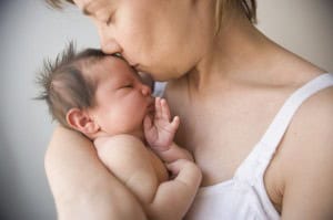 Mother kissing newborn Mother kissing newborn