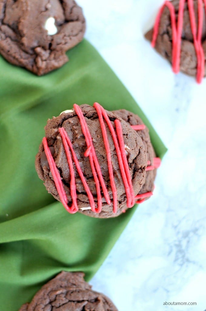 Decadent chocolate cake mix cookies with a mixture of white, dark, and semisweet chocolate chips. Frosted, sprinkled and festive for the holidays.