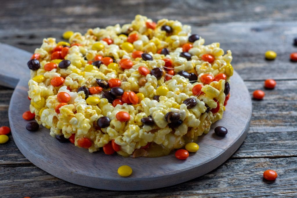 This popcorn cake recipe is a super simple and quick treat that you can make with the kids. The main ingredients of this fun Popcorn Cake are popcorn and candy. It is a wonderful mix of so many flavors. This delicious and super fun Popcorn Cake is a great choice to make and gift to friends and family.