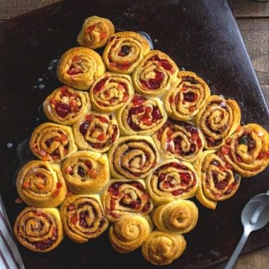 Made with crescent roll dough and dried fruit, this Cinnamon Rolls Christmas Tree recipe is so easy-to-make and fun to eat! Cinnamon Rolls shaped into a Christmas tree is perfect breakfast for Christmas morning.