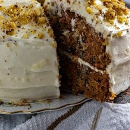This Carrot Cake recipe is incredibly moist thanks to the addition of crushed pineapple. The 2-layer carrot cake is slathered in homemade cream cheese frosting and sprinkled with chopped nuts.