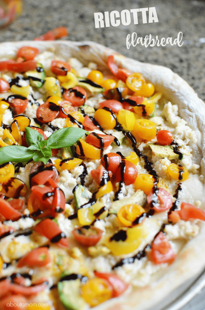 Pizza dough topped with cherry tomatoes, fresh basil, avocado, ricotta, olive oil and sea salt, then finished off with a balsamic glaze. I know you're going to enjoy this Ricotta Flatbread a LOT. Some olives would be a nice addition too.