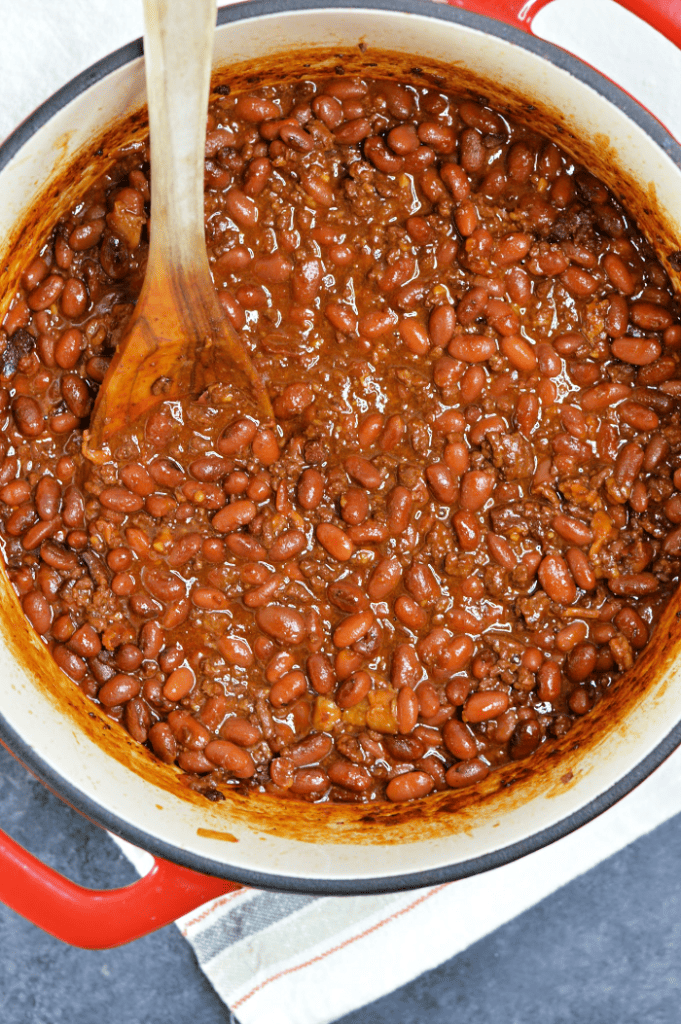 A delicious bean recipe made with ground beef, bacon, a sweet tangy sauce, and a surprising smokey flavor. This BBQ Cowboy Beans recipe is the perfect side dish for tailgating and backyard barbecues.