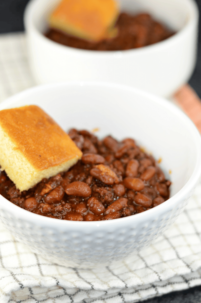 A delicious bean recipe made with ground beef, bacon, a sweet tangy sauce, and a surprising smokey flavor. This BBQ Cowboy Beans recipe is the perfect side dish for tailgating and backyard barbecues.