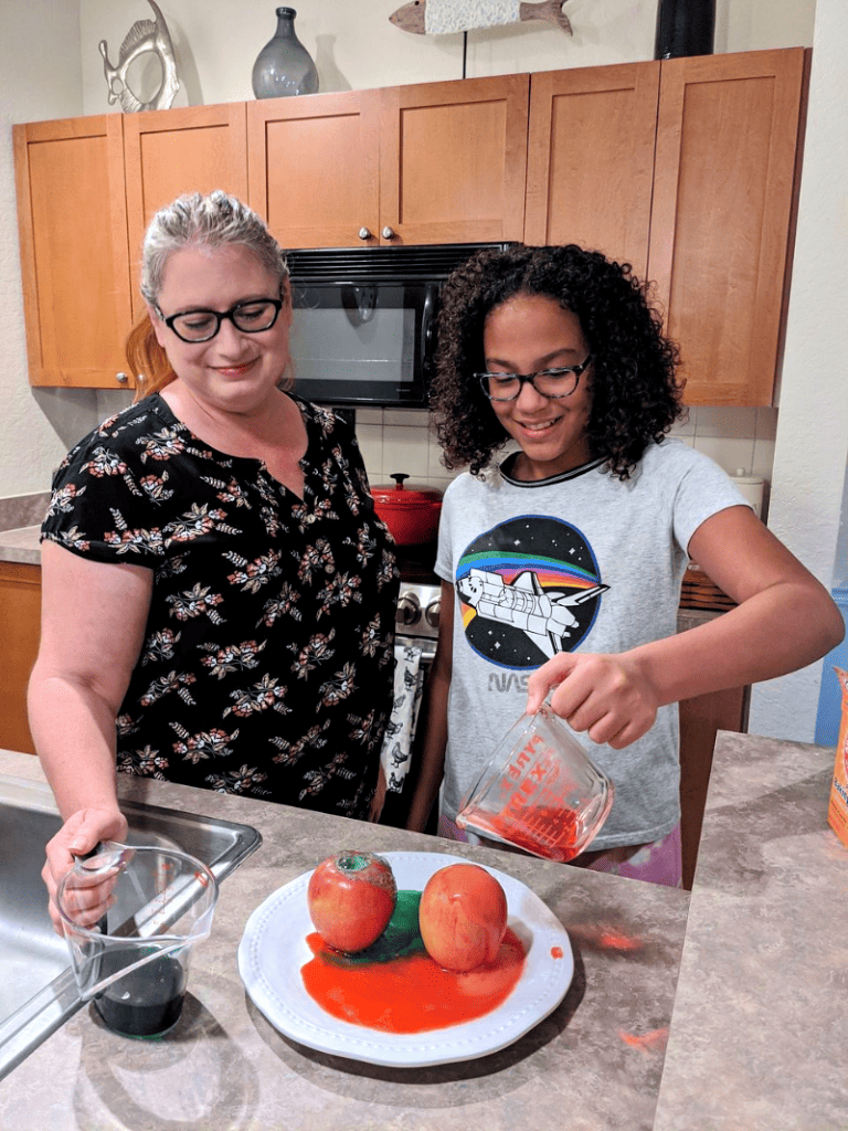 Mãe e filha fazendo ciência experimentam na cozinha.
