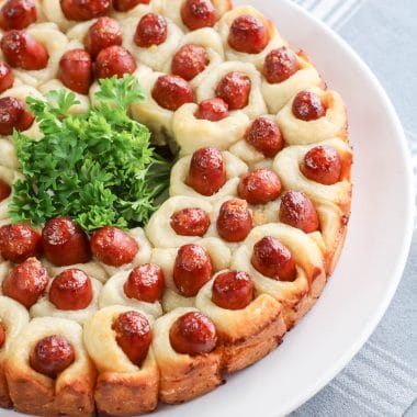 These Pull Apart Pigs in a Blanket are a delicious twist on a classic. Made with refrigerated pizza dough, these pigs in a blanket are super easy to make. Perfect for a party, get together, game day or a picnic, these appetizers are also a fun dinner idea. This is what I consider FUN food.