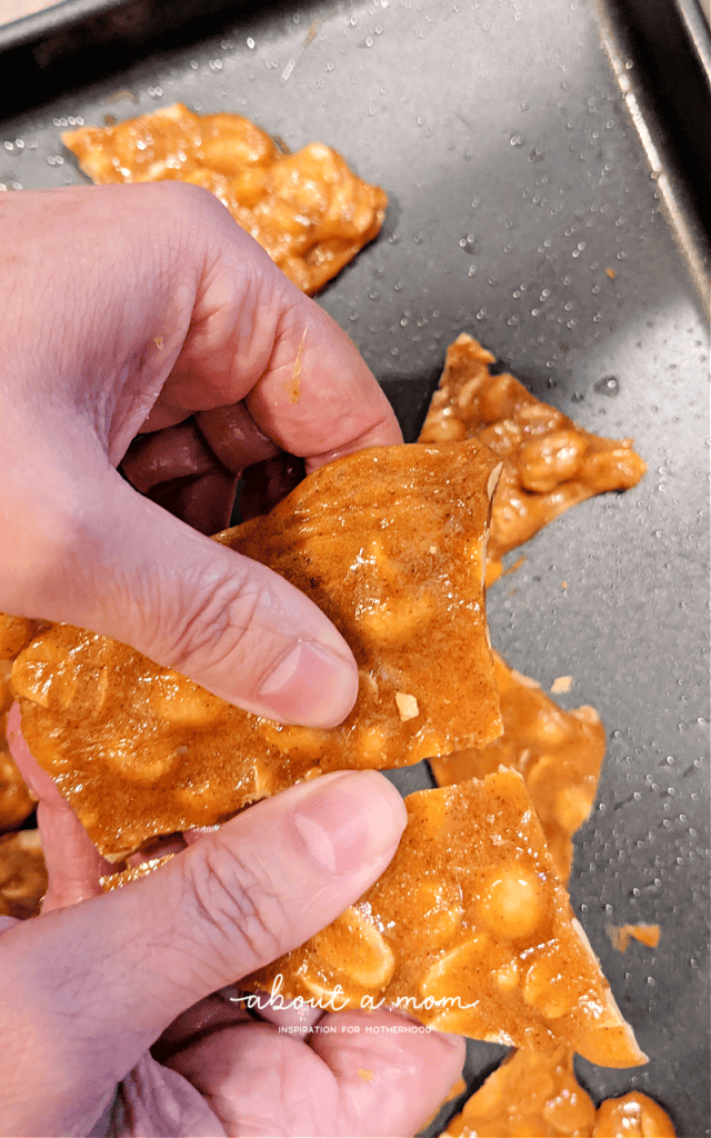 breaking peanut brittle into pieces with hands