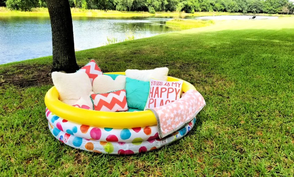 There's nothing more dreamy than spending the summer outdoors with a good book. This DIY outdoor reading nook comes together easily with a kiddie pool, some blankets and pillows.