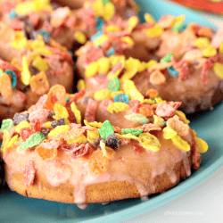 Baked Strawberry Donuts with Strawberry Glaze are made fun and extra delicious with a colorful Fruity Pebbles topping.