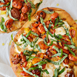 A roasted tomato and basil flatbread topped with extra virgin olive oil and balsamic reduction. This Caprese Flatbread Pizza recipe combines all the ingredients of a classic Caprese salad.