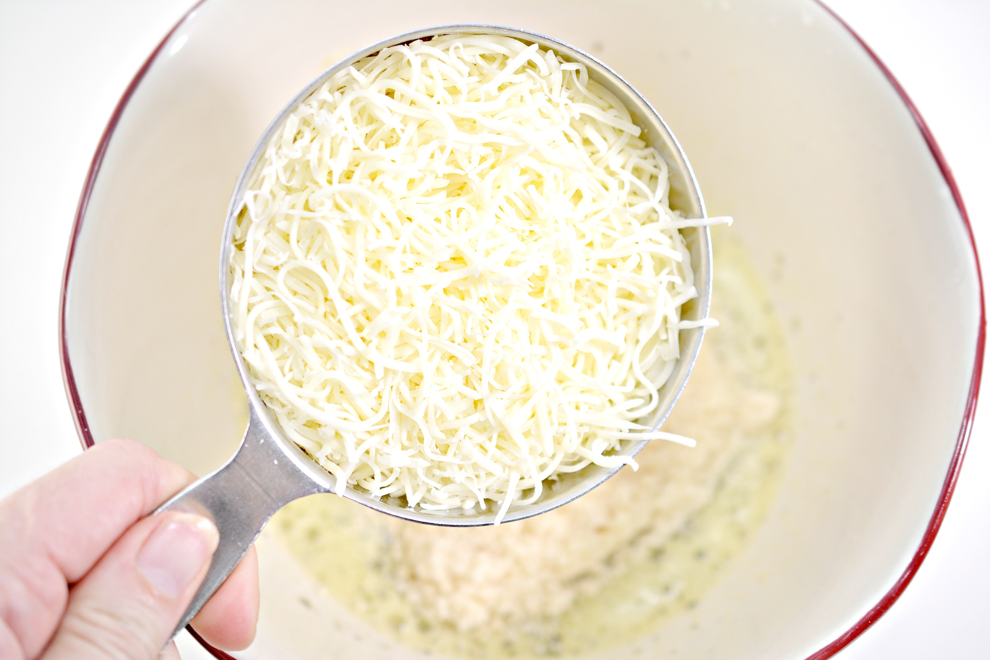 adding cheese to the bowl