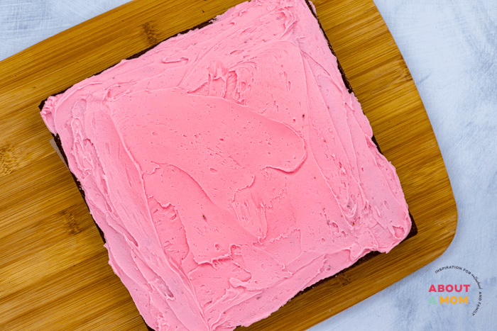 spread pink frosting onto brownies