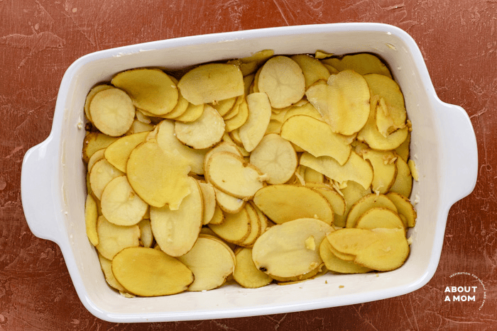 layer sliced potatoes in casserole dish