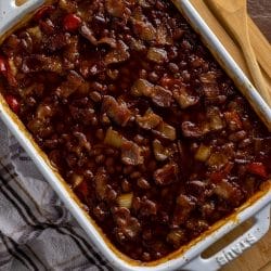 This is simply the best smokey baked beans recipe! This side dish comes together easily with canned beans, peppers, onions, molasses, brown sugar, a few dashes of liquid smoke and some additional pantry staples.