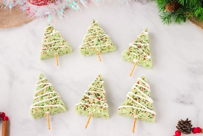 Look at these adorable Christmas Tree Rice Krispie Treats! A delicious twist on a holiday classic! These rice krispies are made to look like festive Christmas trees.